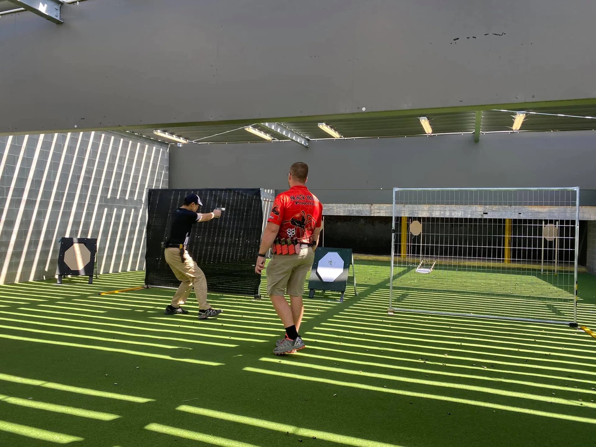 An instructor working with a participant at a practical Lorco Shooting Academy session.