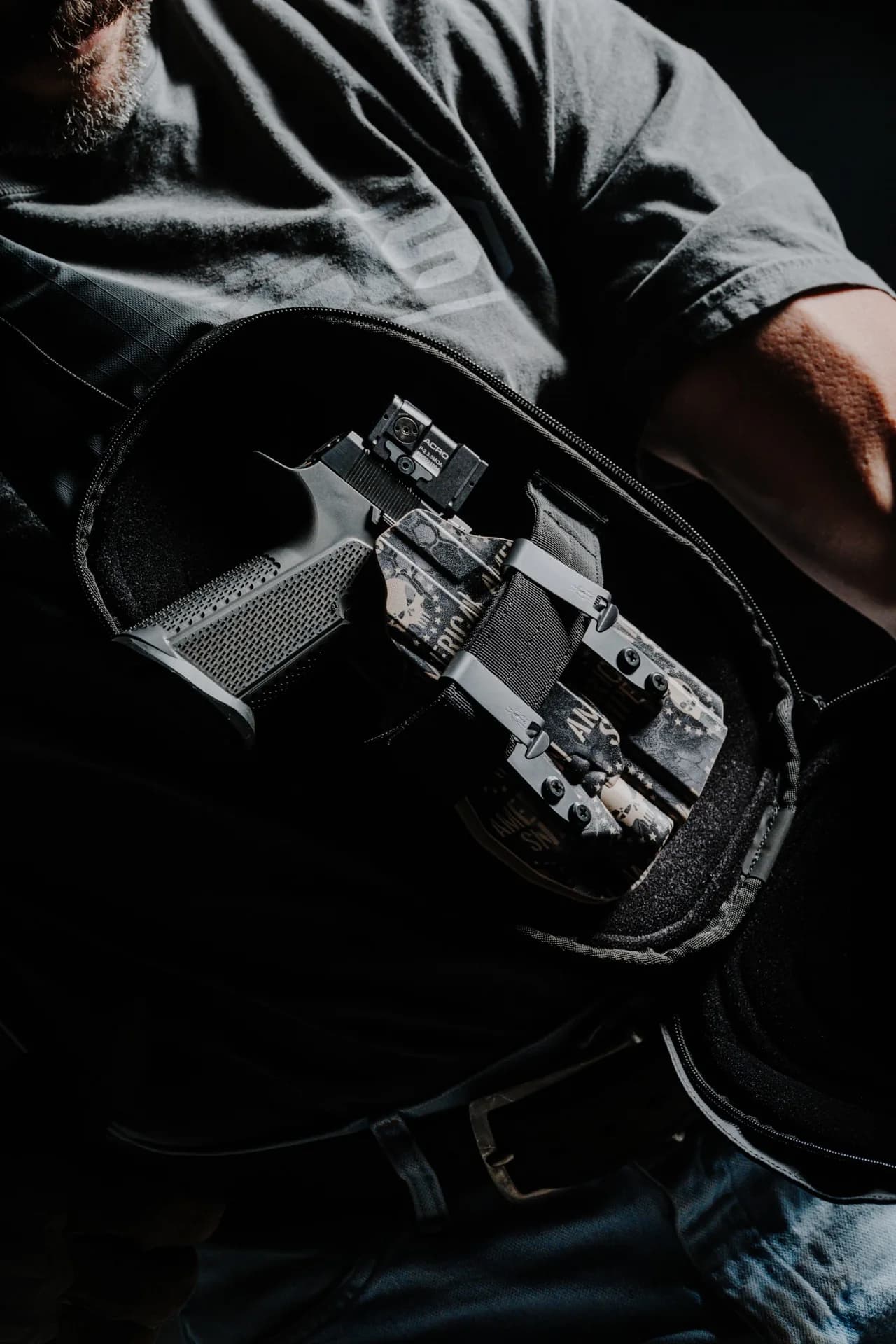 An American Sniper holstered pistol carried in a sling bag.