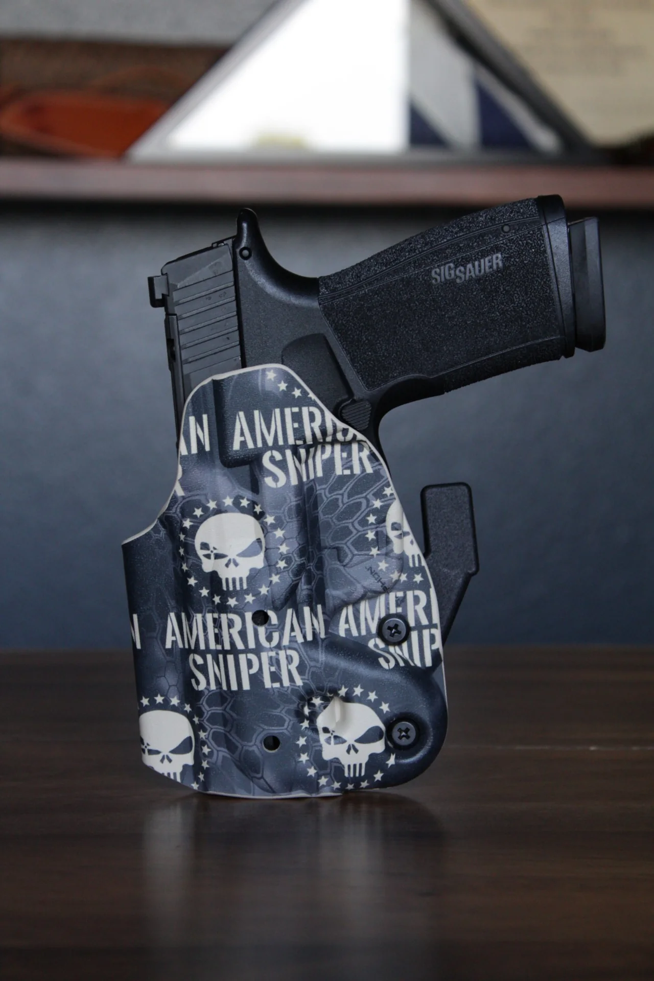 An American Sniper Kydex holster in a black-and-white skull design on a SIG Sauer pistol.