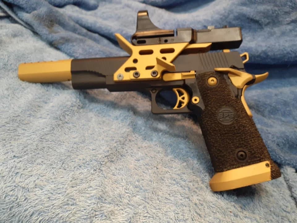 An SPS 2011 pistol finished with gold Cerakote accents.
