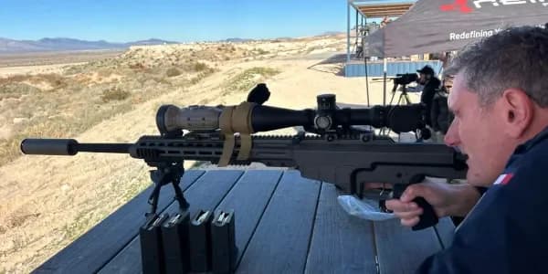Wayne Lording behind a suppressed precision rifle at an outdoor bench.